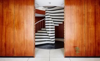 Wooden paneled walls and a black and white spiral staircase