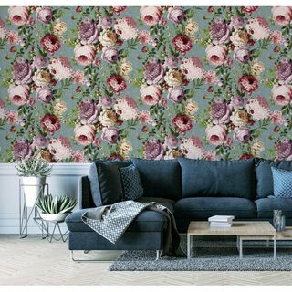 Floral botanical wallpaper behind blue fabric couch in living room