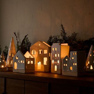 Wooden table with seven ceramic village candlestick pieces