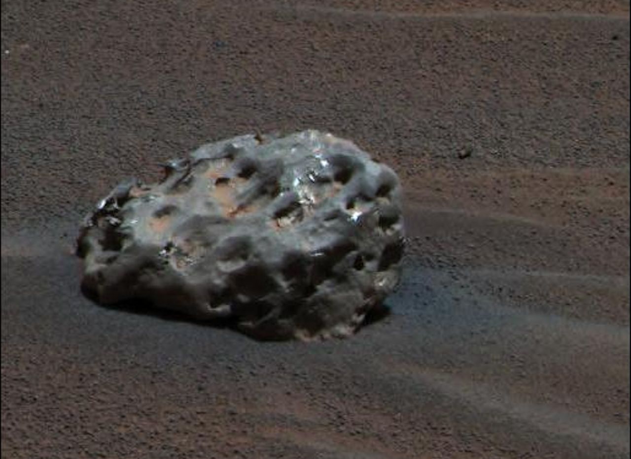 A photograph of an iron meteorite sitting on the surface of Mars