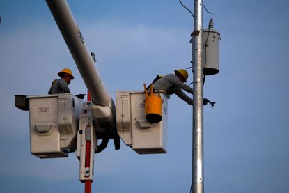 Utility workers in Puerto Rico work to restore power
