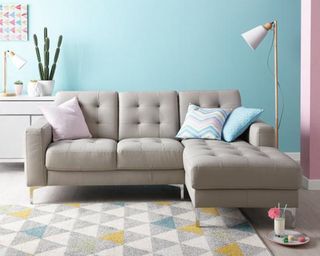 living room with light blue wall grey sofa and lamp