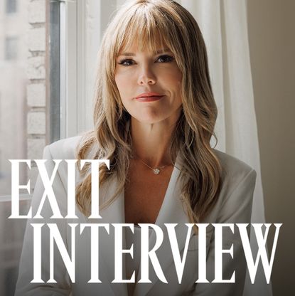 Wendy McMahon wearing a white two piece suit posed seated against a white window