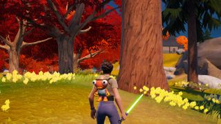 Fortnite - A player holding a lightsaber stands in front of a very tall timber pine tree