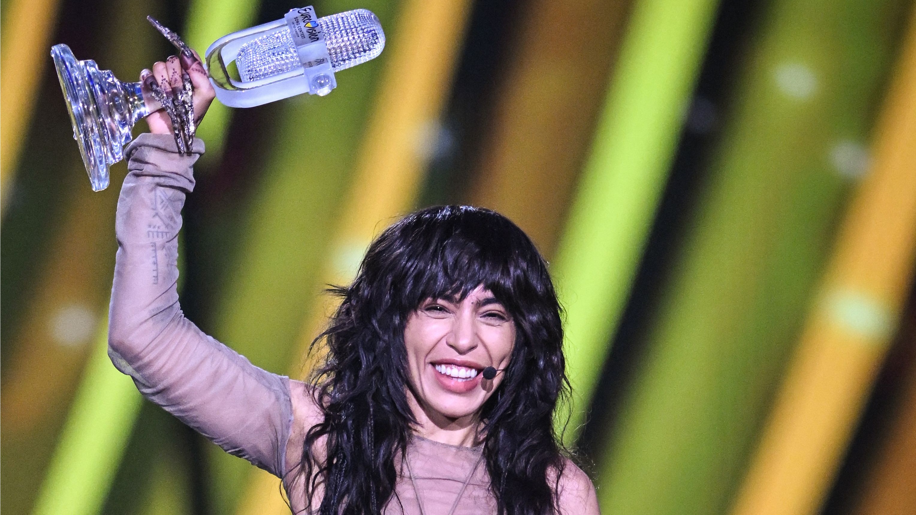Loreen holding the Eurovision trophy on-stage after winning the Eurovision Song Contest 2023
