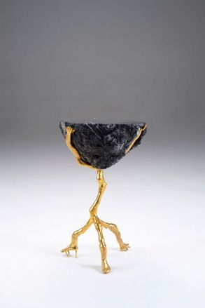 Gold frame holding a large black rock