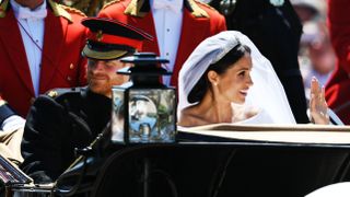Prince Harry and Meghan Markle ride in a carriage on their wedding day.