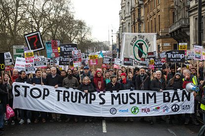 Protesters stand up against the immigration executive order by President Trump.