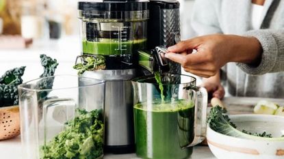 What to do with juicer pulp: Nama juicer with pulp coming out of one side and juice coming out of the other
