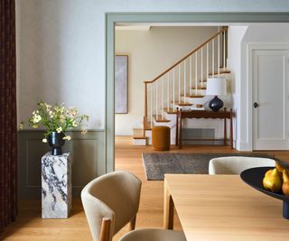 dining room with cream chairs and wood table view to stairway