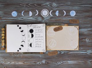 Moon calendar 2022: Book of Shadows with lunar phases on wooden altar.
