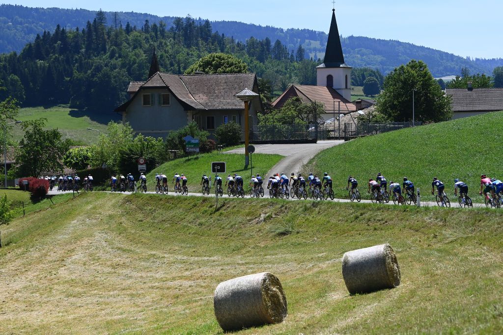GRENCHEN SWITZERLAND JUNE 14 A general view of the Peloton passing through Epauvillers Village during the 85th Tour de Suisse 2022 Stage 3 a 1769km stage from Aesch to Grenchen ourdesuisse2022 WorldTour on June 14 2022 in Grenchen Switzerland Photo by Tim de WaeleGetty Images