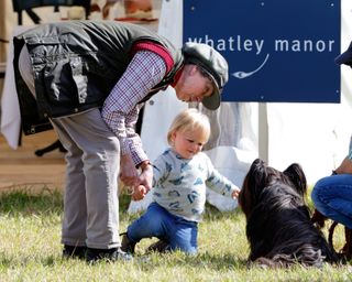 Princess Anne, The Princess Royal and granddaughter Mia Tindall meet a dog as they attend day 2 of the Whatley Manor International Horse Trials at Gatcombe Park on September 12, 2015 in Stroud, England.
