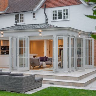 Large orangery with kitchen-living area inside and steps down to garden terrace