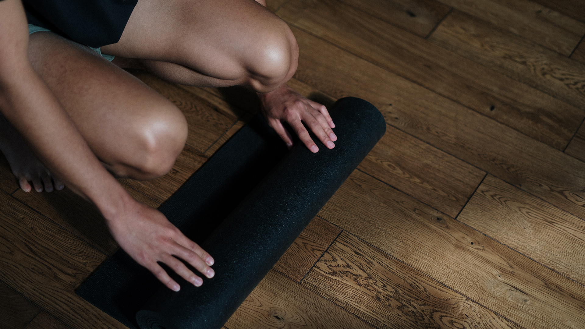 man rolling out yoga mat