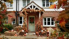 House decorated for Halloween with autumn wreath, pumpkins and baskets