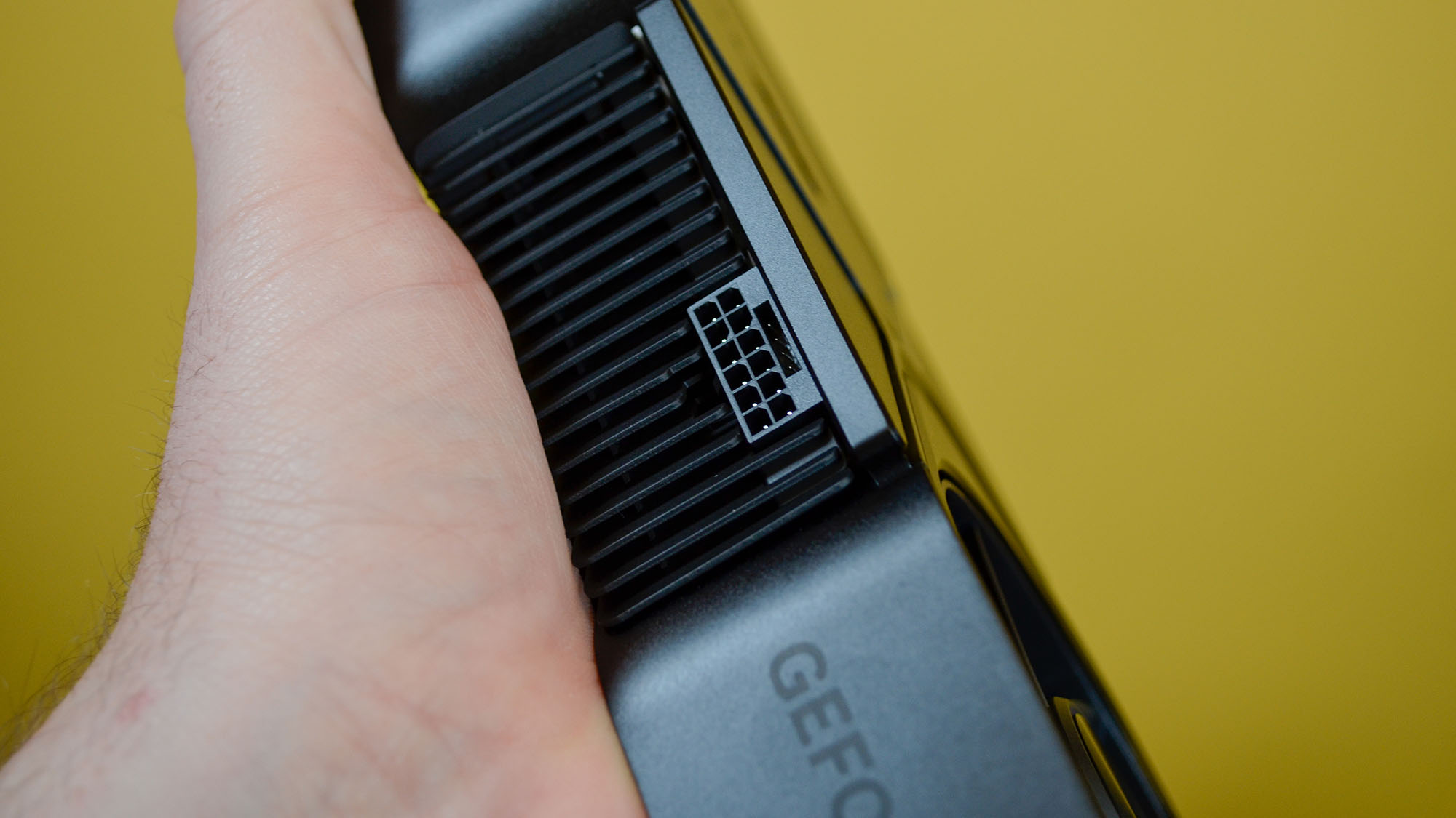 An Nvidia GeForce RTX 4070 Super on a desk in front of a yellow background