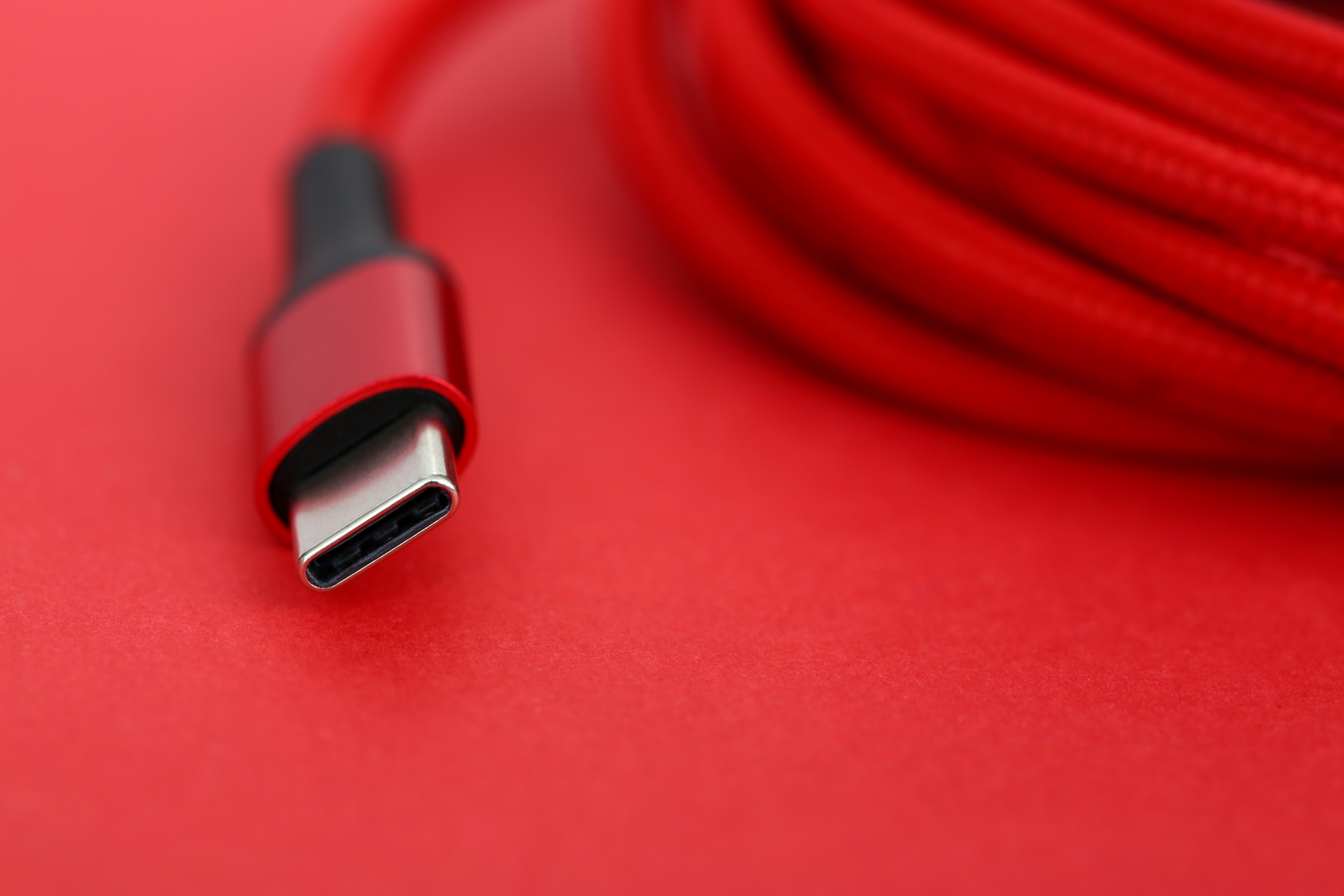 Rotes USB-Kabelende, das auf dem Tisch liegt, extreme Nahaufnahme