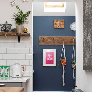 A kitchen view into hallway with skylight and a blue wall