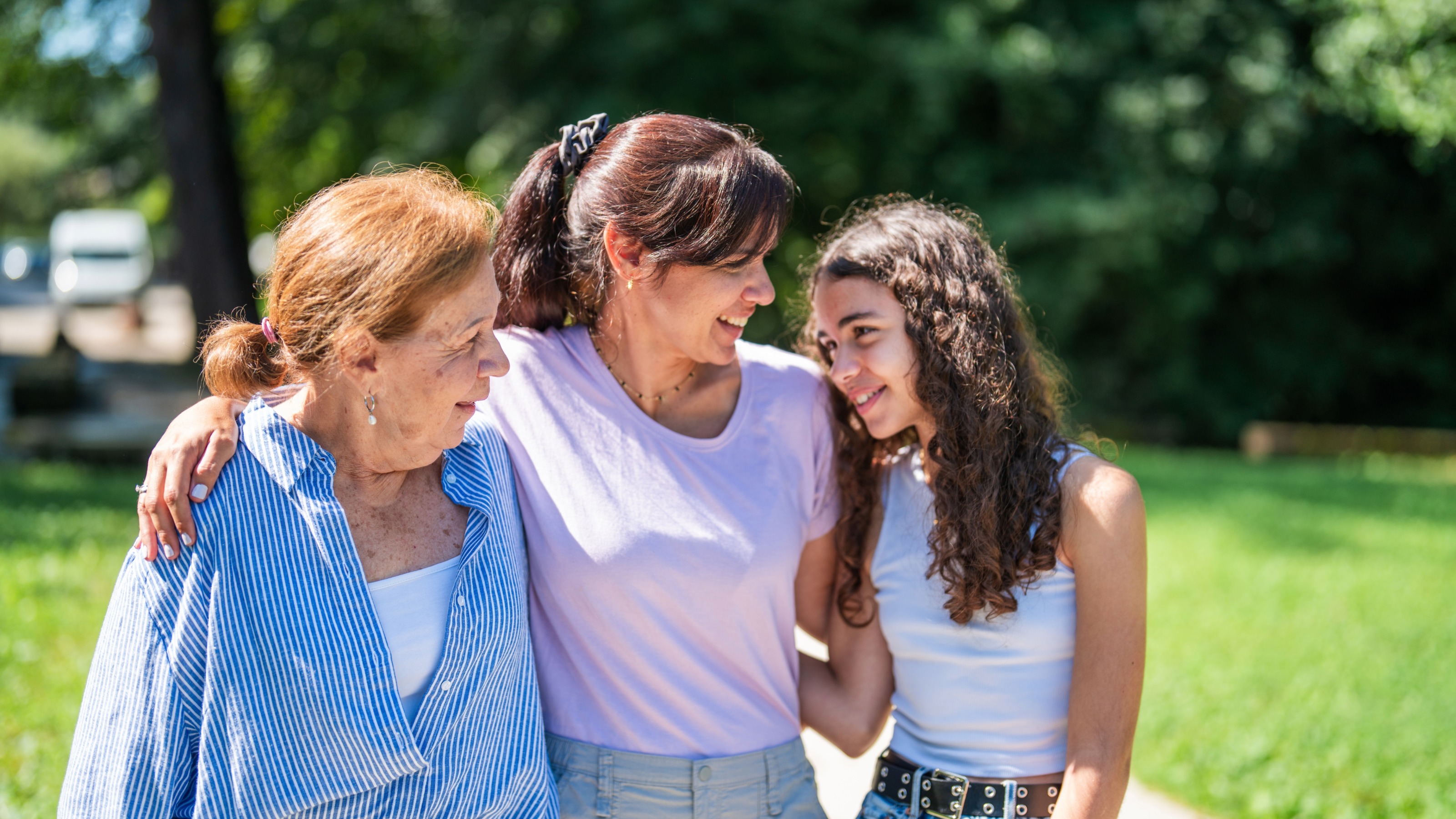 A grandmother, mother and teenage daughter enjoy a sunny day outside