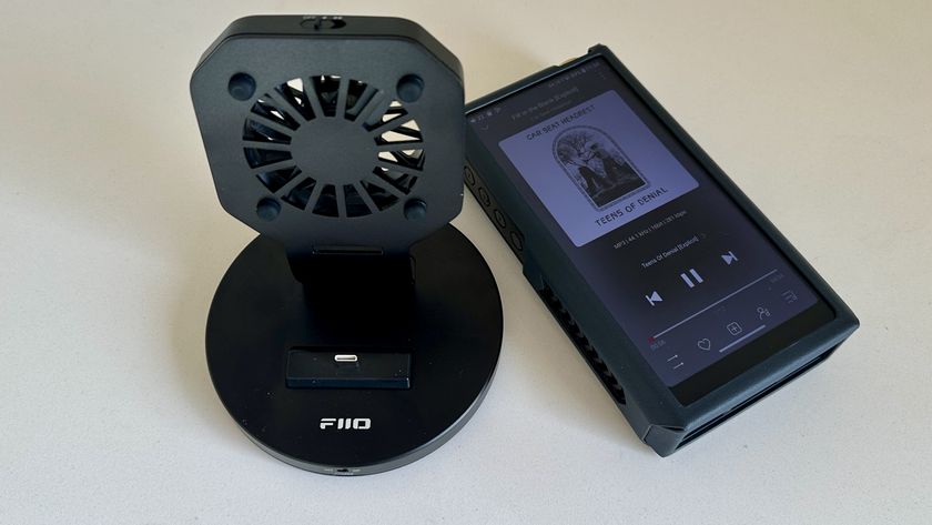 The FiiO M27 player with screen and dial showing, and content on the screen, on beige or yellow background