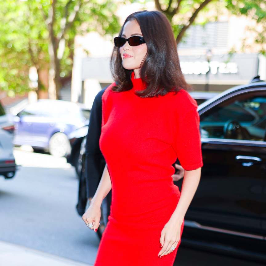 selena gomez wearing a red dress and dark sunglasses