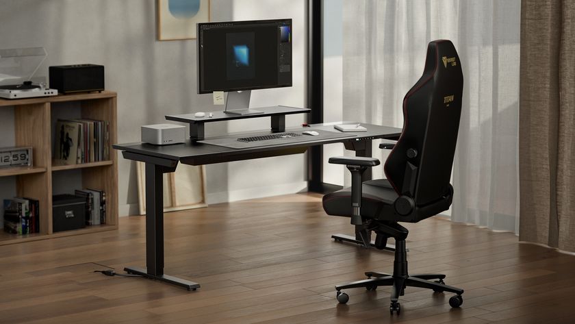 Secretlab Magnus Evo desk next to chair with monitor and riser on top.