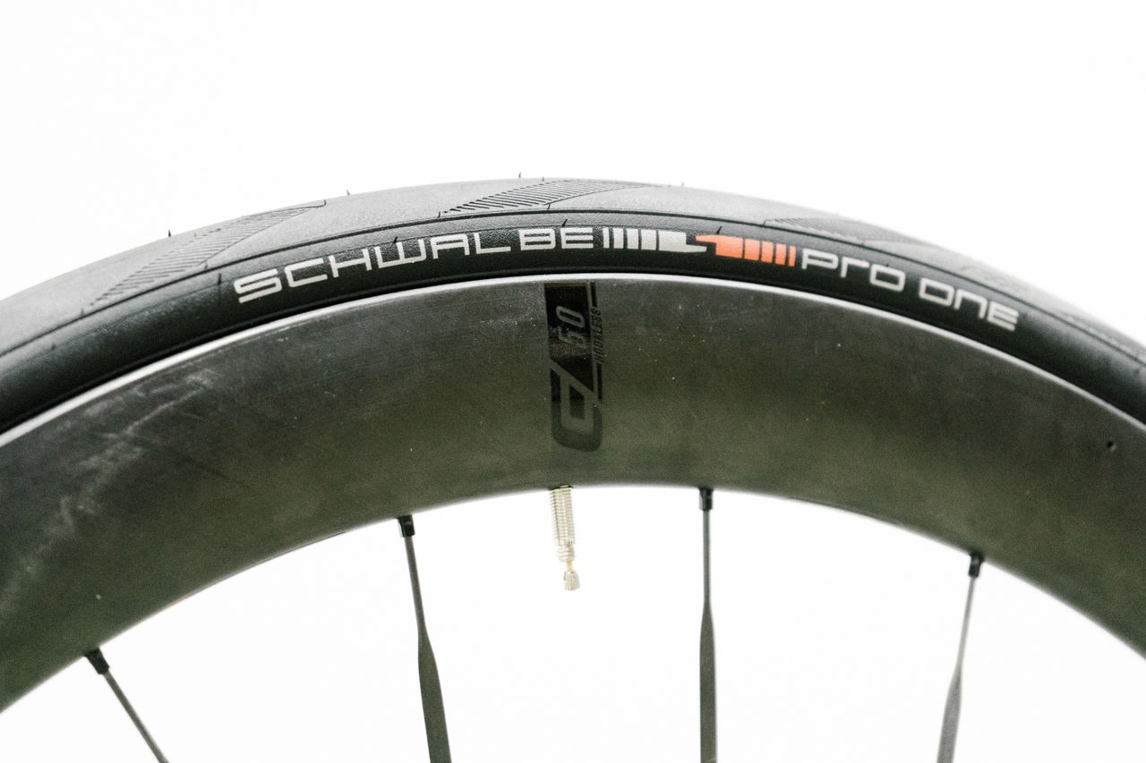 An aero road wheel stands against a white wall