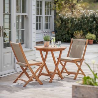 a wooden bistro set on a decked patio