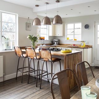 kitchen with white walls chairs and hanging lamp