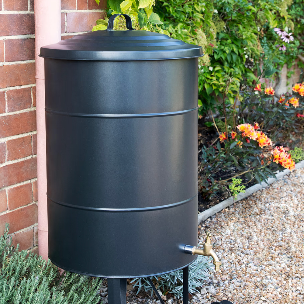 black metal bin water butt with a brass tap