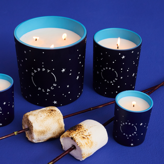 Marshmellow candlenext to two toasted marshmallows