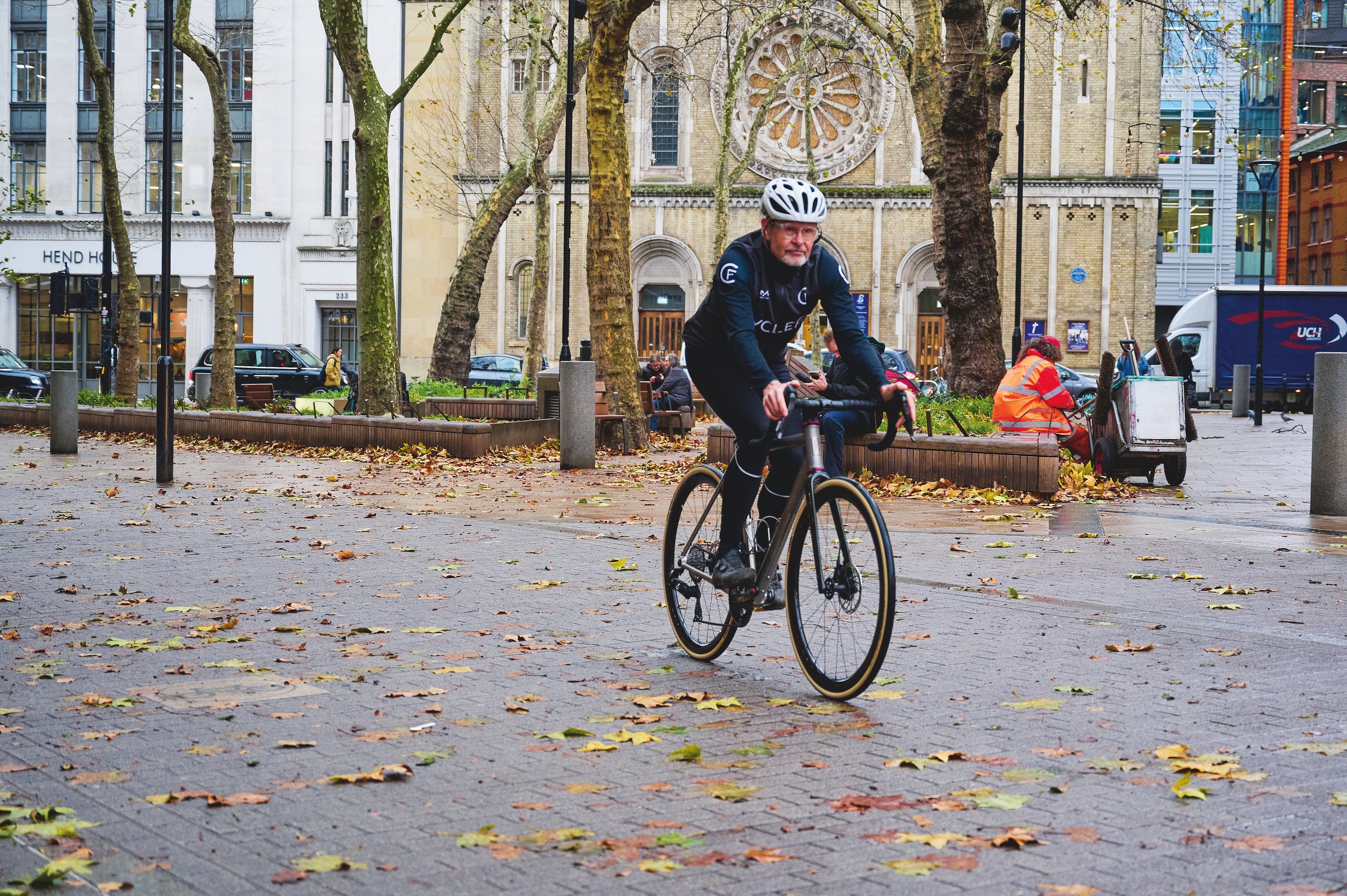 Phil Cavell in black kit riding his bike in London