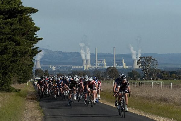 The peloton on skinny roads near Moe with one of the many power stations in the area in the distance.