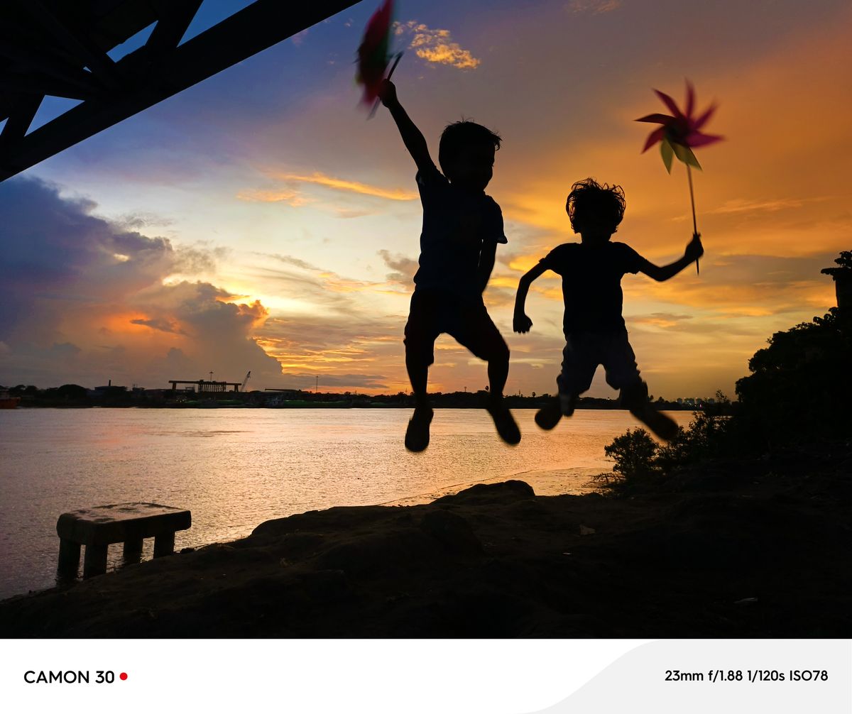 Two children jump silhouetted against a sunset in Myanmar