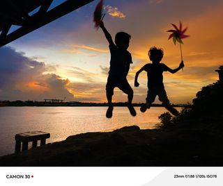 Two children jump silhouetted against a sunset in Myanmar