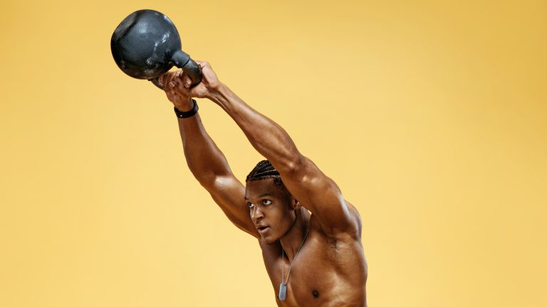 person doing kettlebell swings in front of a yellow background