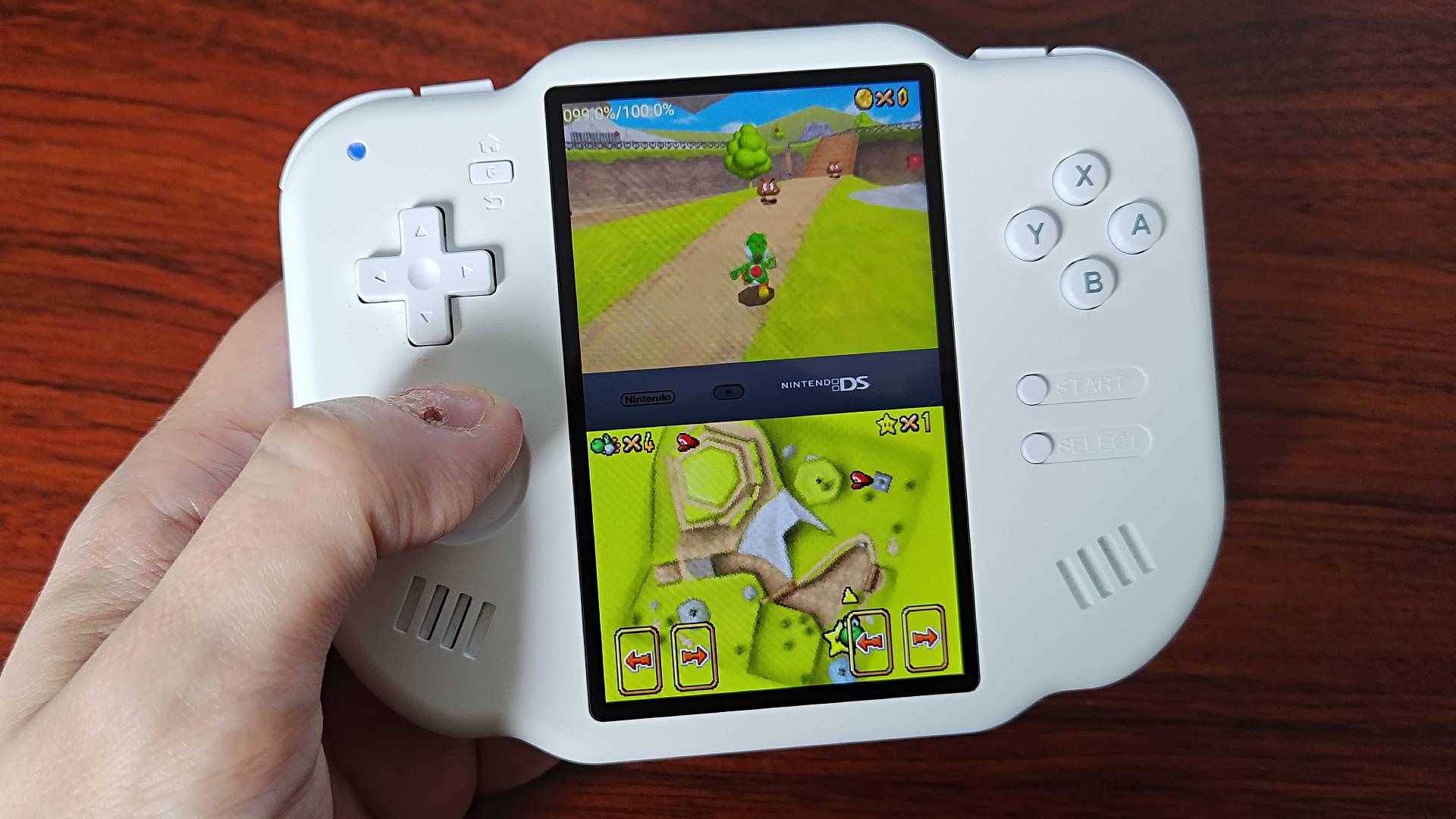 Hand using thumb stick to play Super Mario 64 DS on MagicX Zero 40.