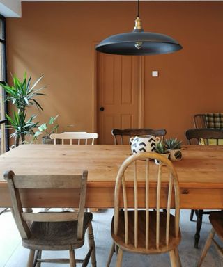 kitchen with burnt orange walls, door and wooden table and chairs