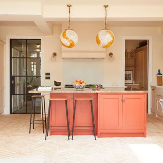 orange kitchen with brick herringbone floor