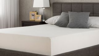 The Zinus green tea memory foam mattress dressed with grey cushions and white pillows