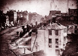 Boulevard du Temple, Paris, France, photographed by Louis Daguerre. Believed to be the earliest photograph showing a living person. Only the two men near the bottom left corner, one apparently having his boots polished by the other, stayed in one place long enough to be visible 1838. (Photo by: Universal History Archive/Universal Images Group via Getty Images)