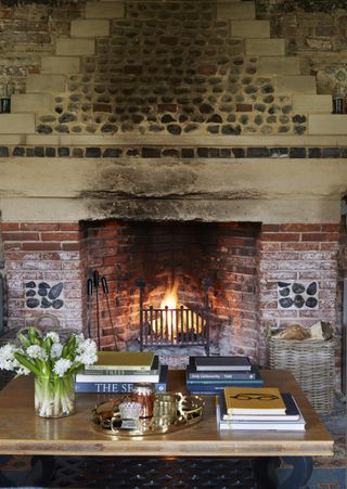 fireplace in living room of flint-and-brick house