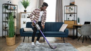 Man using vacuum cleaner to clean living room