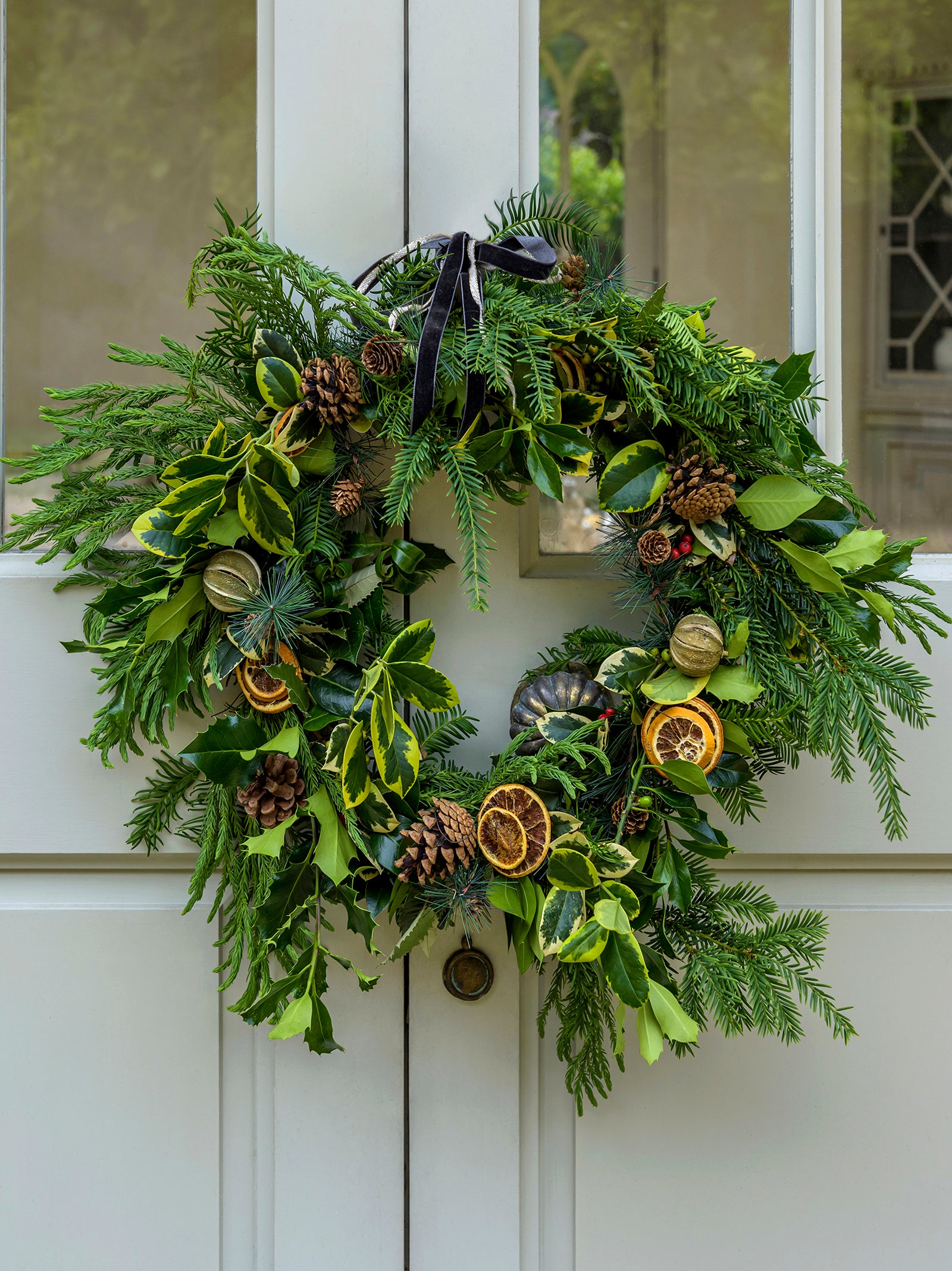 Foliage winter wreath decorated with dried citrus fruits and pinecones.