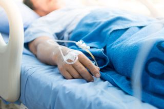 man's hand in hospital bed