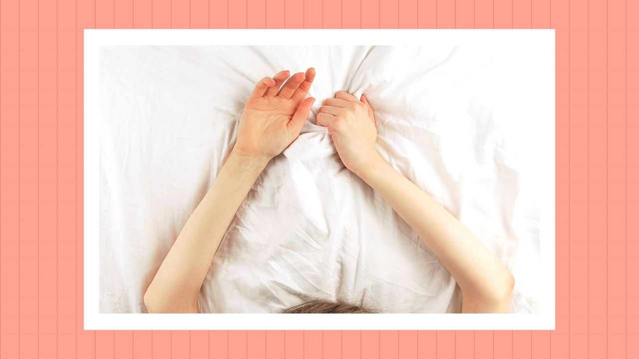 woman with her hands above her head on a bed with white sheets, with a pink border around the image