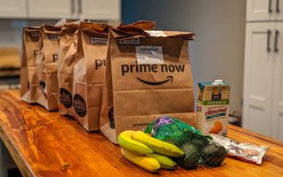 Amazon Prime Now paper grocery bags lined up on a counter 
