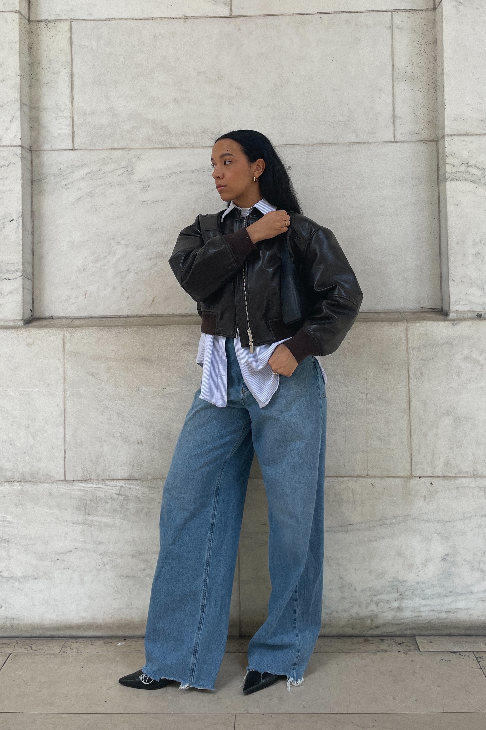 lauren tappan wearing aritzia's leather bomber jacket with a button-down shirt, jeans, and boots