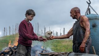 Alfie Williams receives a human skull from Ralph Fiennes in 28 Years Later